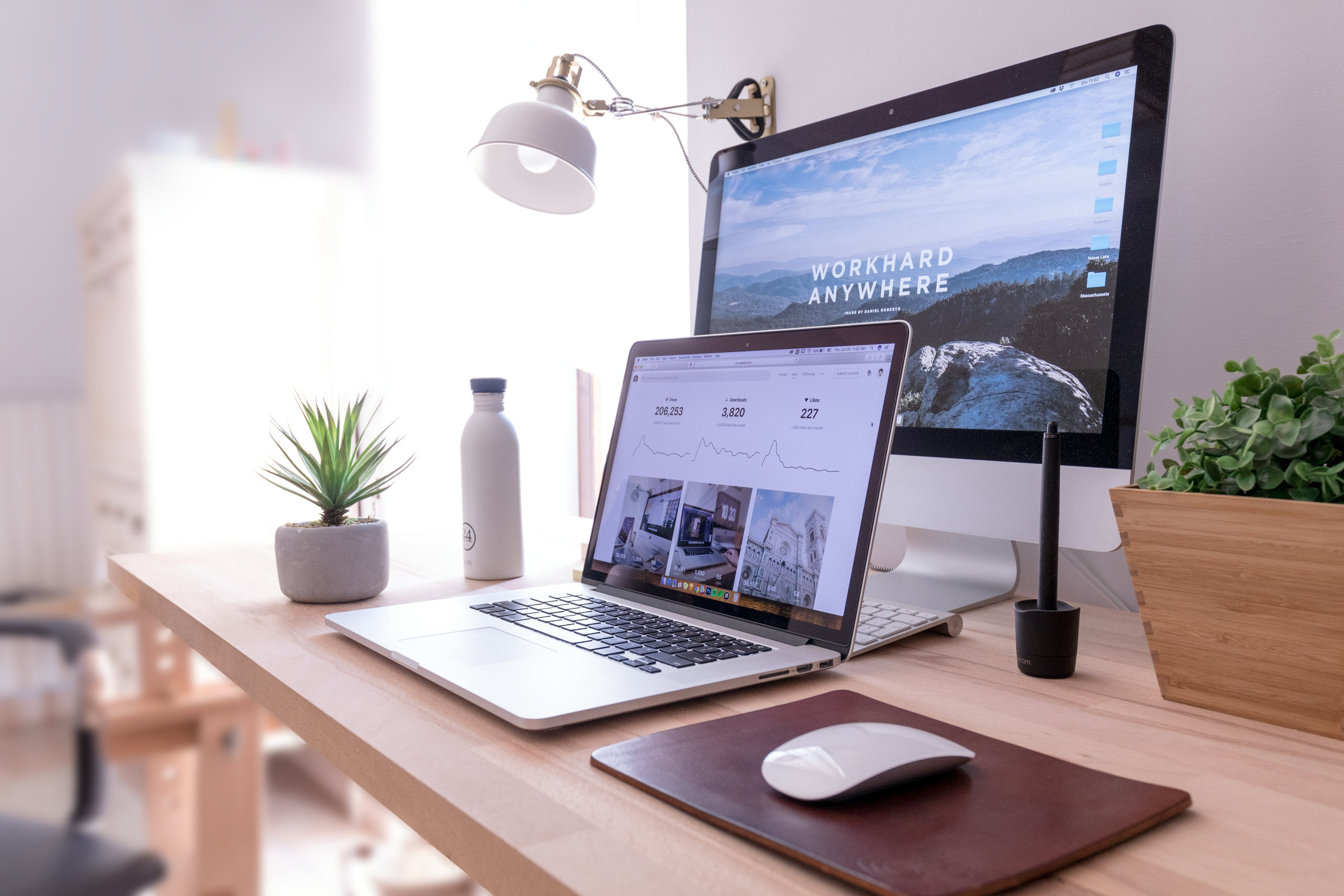 Home office setup with laptop, monitor, and desk decor.