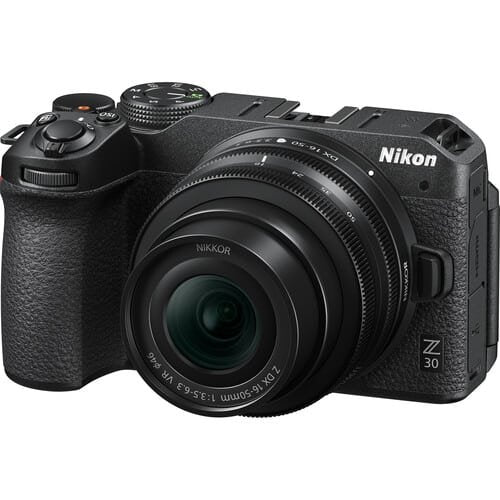 Black Nikon camera with Nikkor lens on a white background